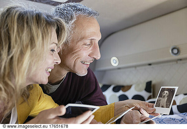 Smiling mature couple looking at photograph in motor home