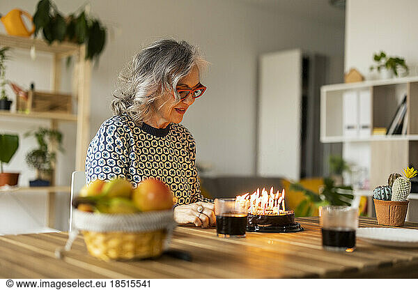 Smiling mature woman celebrating birthday at home