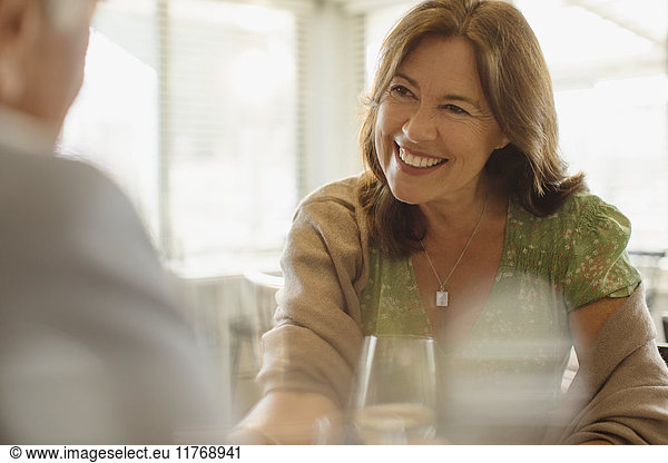 Smiling mature woman enjoying date  dining at restaurant