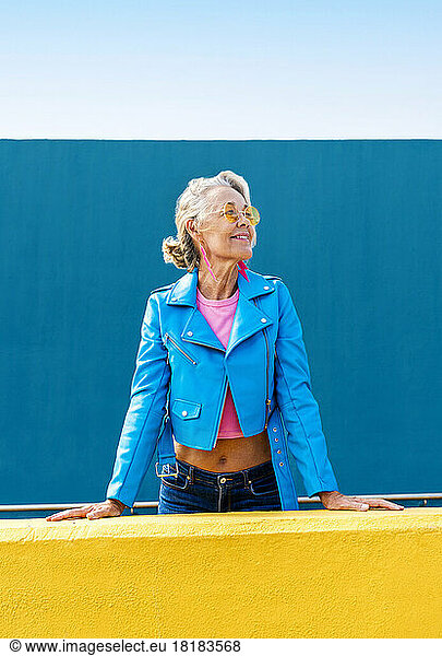 Smiling mature woman in front of blue wall