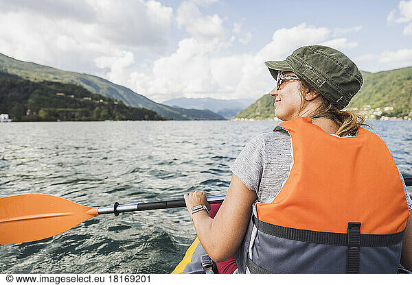 Smiling mature woman kayaking at lake
