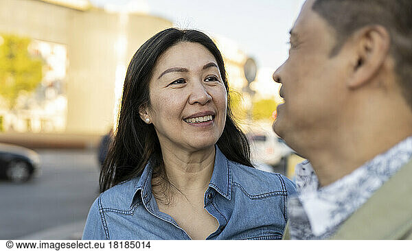 Smiling mature woman looking at man on footpath