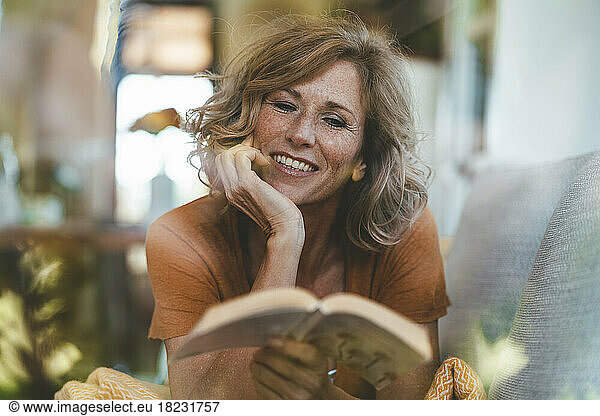 Smiling mature woman reading book