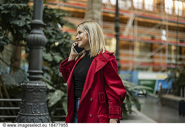 Smiling mature woman talking on smart phone at street