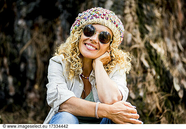 Smiling mature woman wearing sunglasses and knit hat