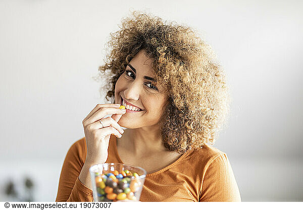 Smiling mid adult woman eating a cookie