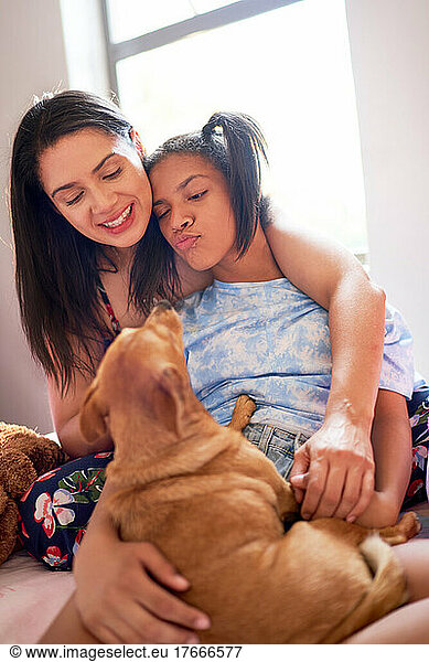 Smiling mother and disabled daughter with cute small dog
