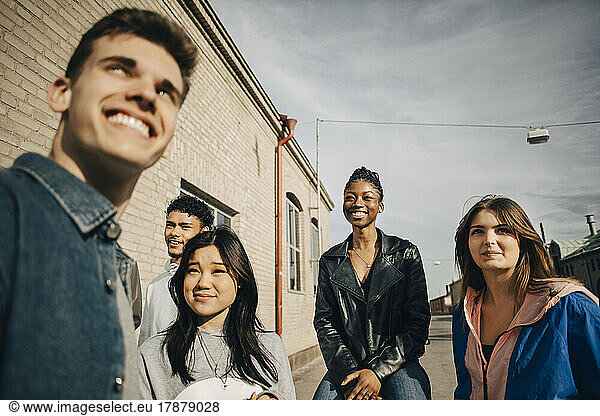 Smiling multiracial young multiracial friends on sunny day