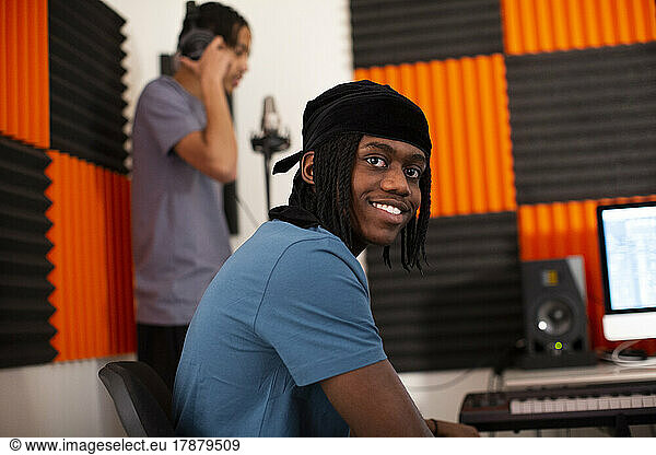 Smiling music composer sitting in recording studio