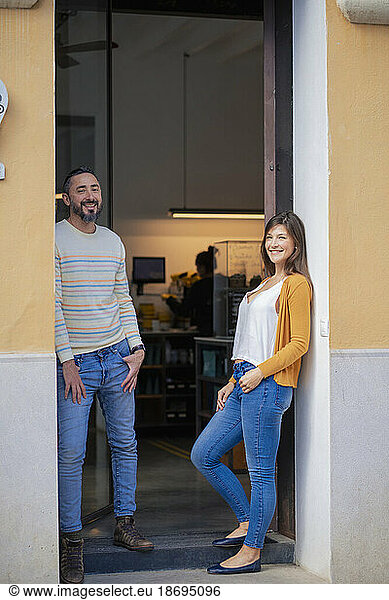 Smiling owners standing at coffee shop doorway