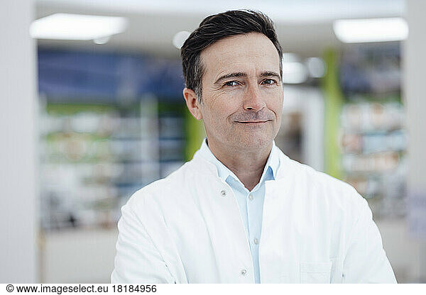 Smiling pharmacist wearing lab coat in pharmacy