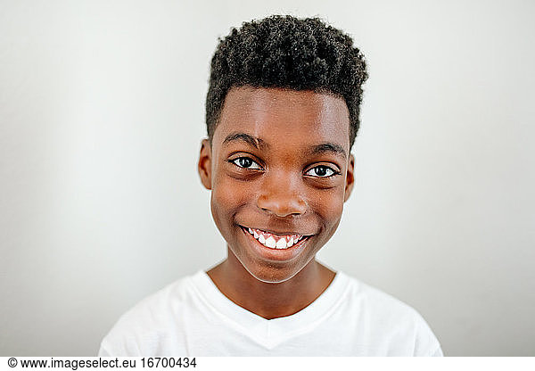 Smiling preteen black boy wearing white tshirt