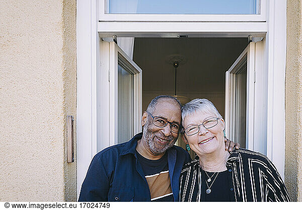 Smiling senior couple in balcony at home