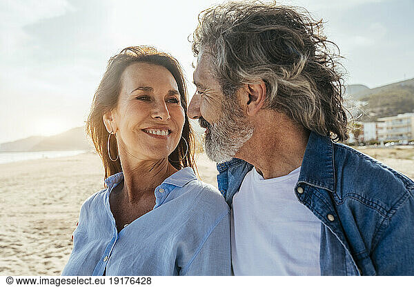 Smiling senior man and woman looking at each other on weekend
