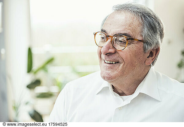Smiling senior man wearing eyeglasses at home