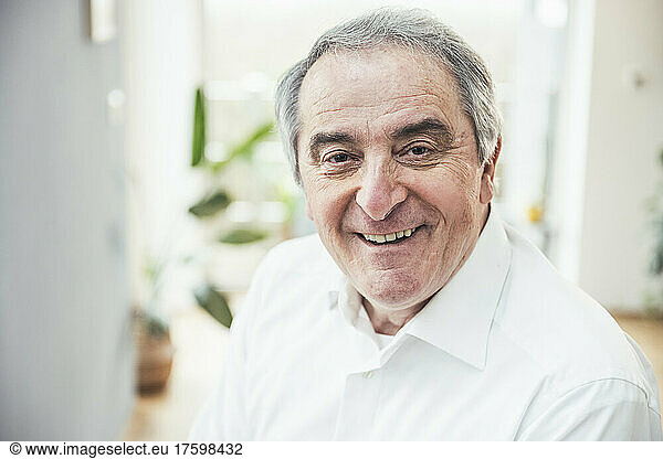 Smiling senior man with gray hair at home