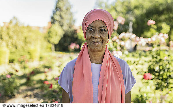 Smiling senior woman with headscarf in park