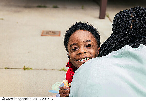 Smiling son embracing mother in backyard