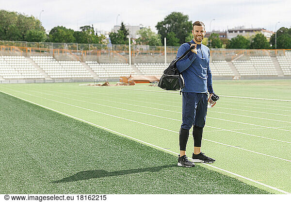 Smiling sportsman standing on sports field