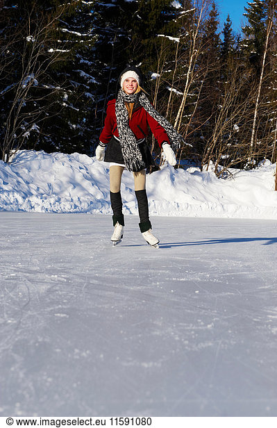 Smiling teenage girl ice-skating