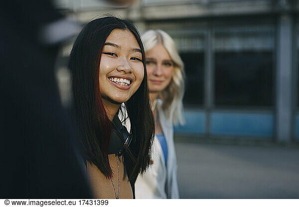 Smiling teenage girl with female friend