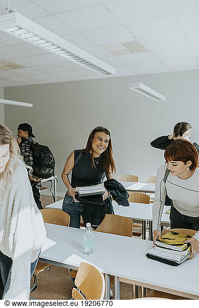 Smiling teenage girl with friends in classroom