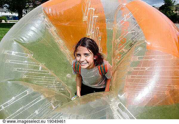 Smiling tween girl in an inflatable bubble soccer suit