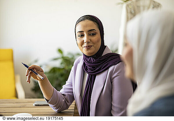 Smiling wedding planner having discussion with colleague