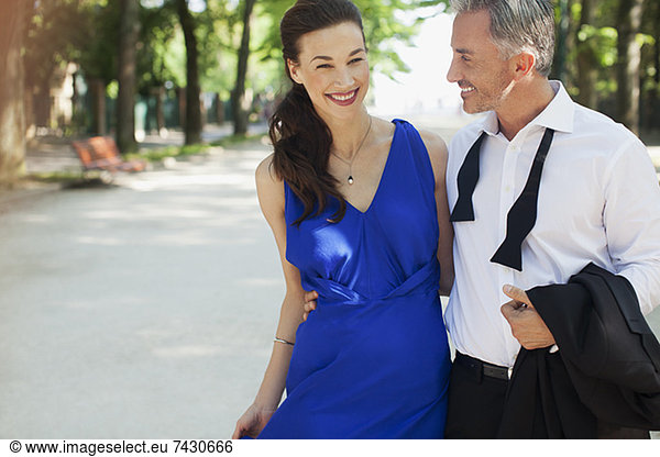 Smiling well-dressed couple in park