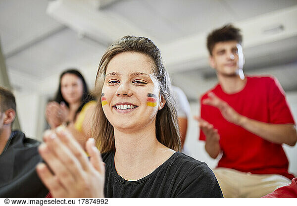 Smiling woman applauding at sports event in stadium