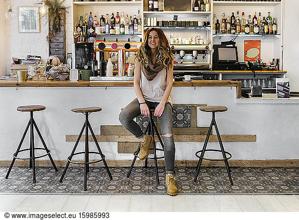 Smiling woman at bar in coffee shop