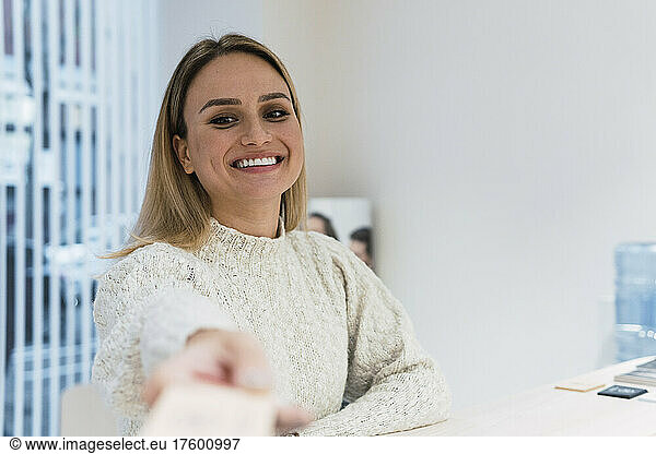 Smiling woman at reception desk in clinic