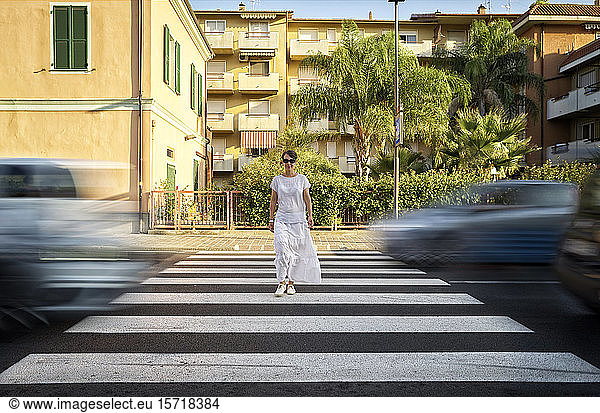 Smiling woman crossing the street on zebra crossing  Italy