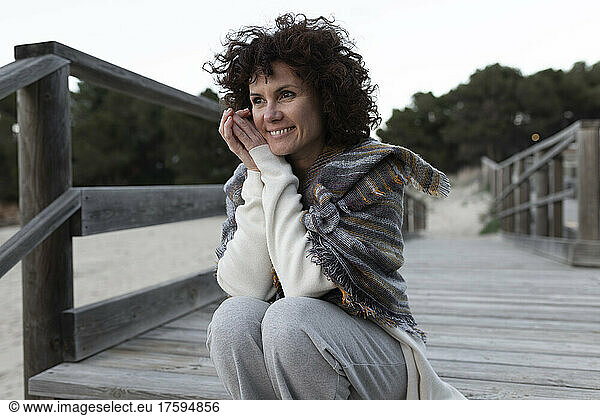 Smiling woman day dreaming at beach