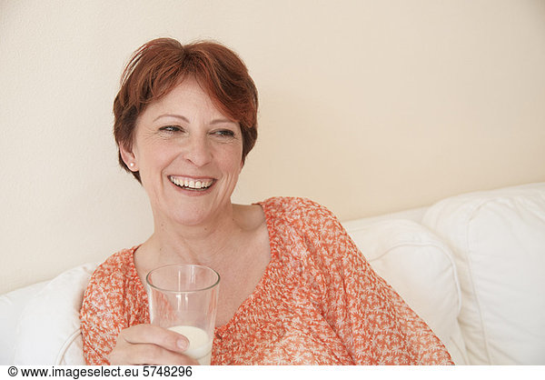 Smiling woman drinking glass of milk