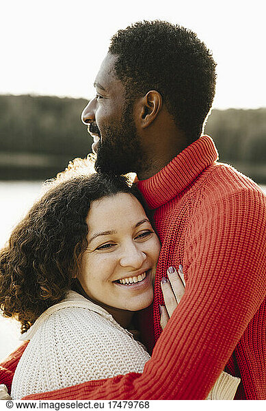 Smiling woman embracing boyfriend during weekend