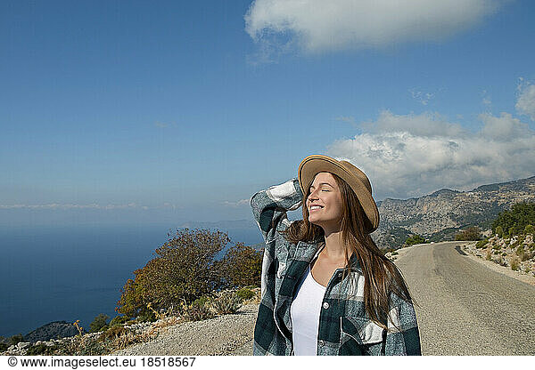 Smiling woman enjoying nature on sunny day at vacation