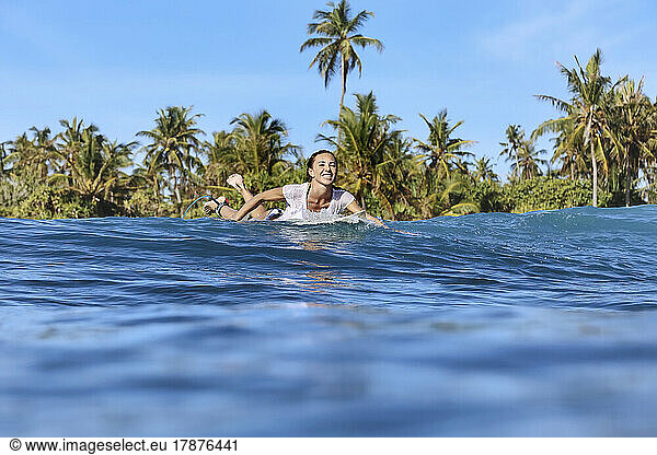 Smiling woman enjoying surfing on sea