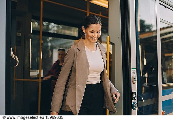 Smiling woman exiting from tram during city exploration