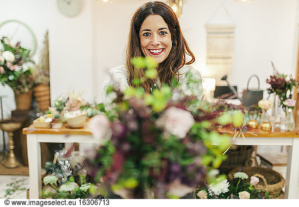 Smiling woman holding bouquet while standing at flower shop