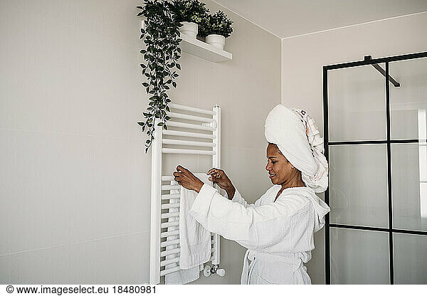 Smiling woman holding towel standing in bathroom
