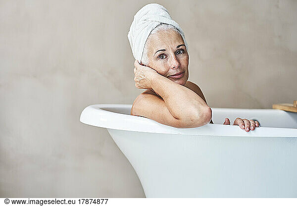 Smiling woman in bathtub at home