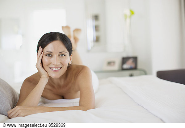 Smiling woman laying on bed