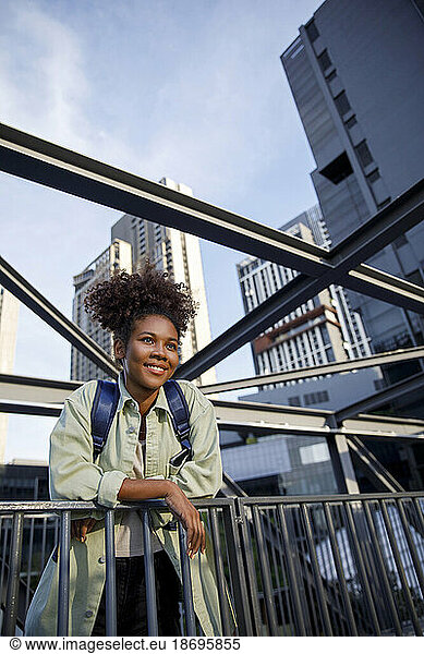 Smiling woman leaning on railing