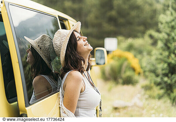 Smiling woman leaning on van