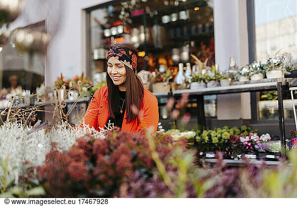 Smiling woman looking at flowers on retail display