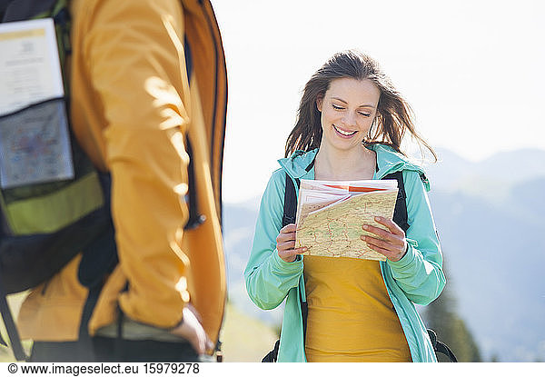 Smiling woman looking at map  Wallberg  Bavaria  Germany