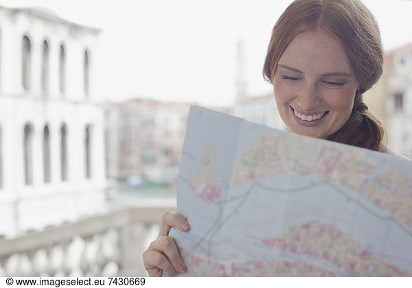 Smiling woman looking down at map