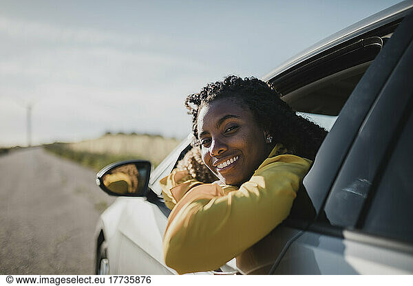 Smiling woman looking out through car's window
