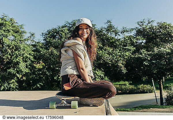 Smiling woman on skateboard in park